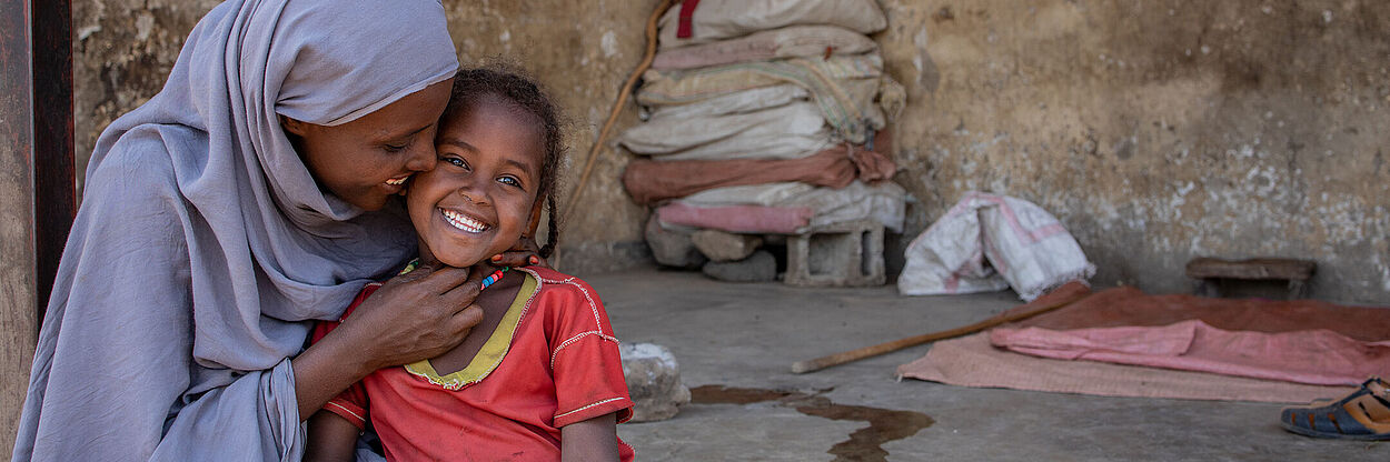 Eine Mutter hält ihr Kind in den Armen.