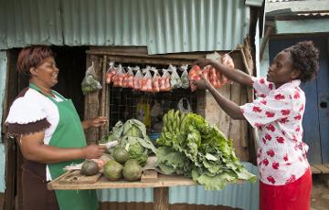 Zwei kenianische Frauen stehen am Marktstand