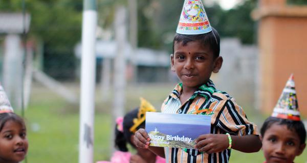 Junge in Sri Lanka hat zum Geburtstag eine Karte von seinem Paten bekommen