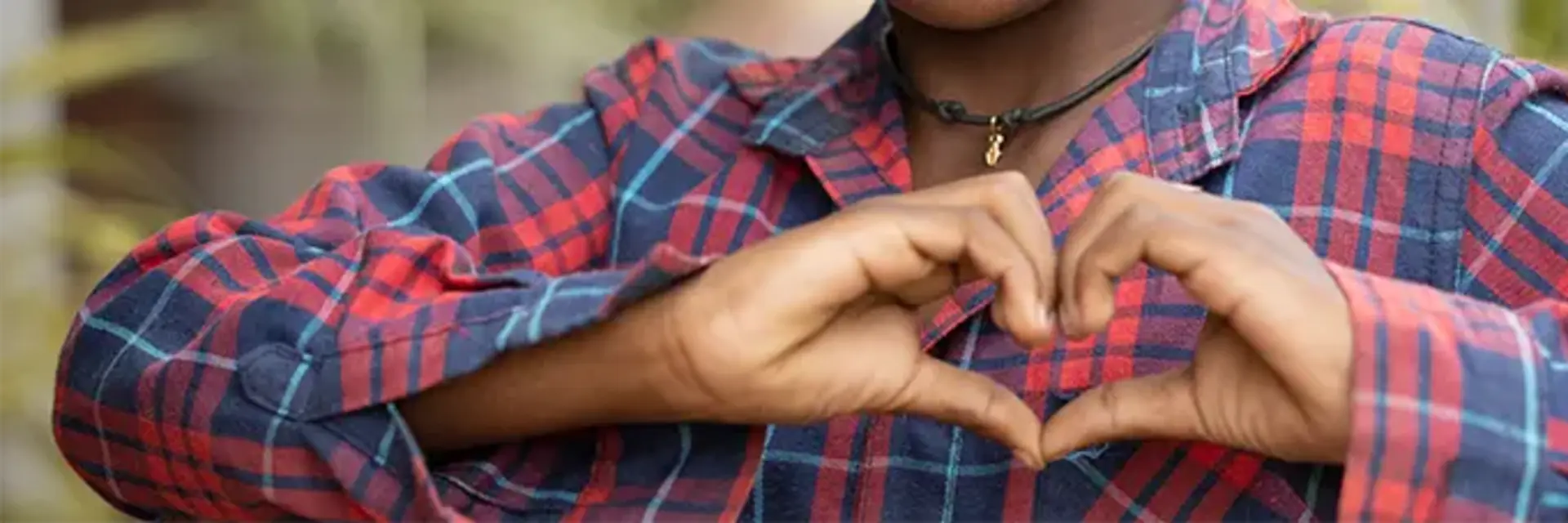 Ein Kind zeigt ein Herz.