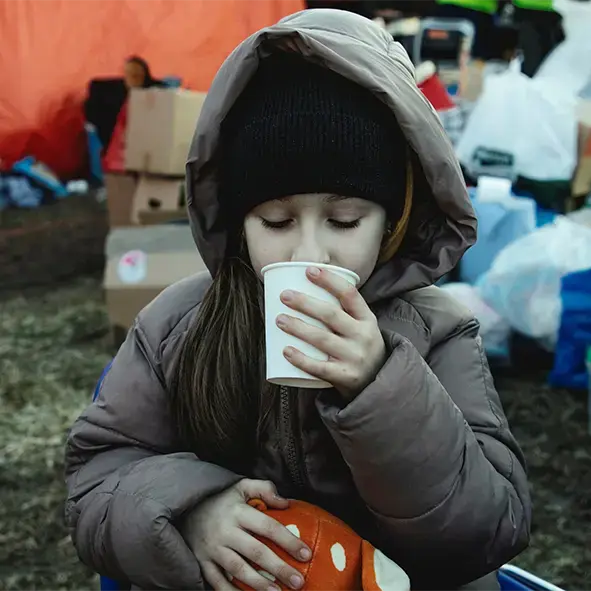 Ukrainisches Kind trinkt aus einem Becher.
