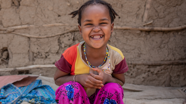 Ein äthiopisches Mädchen lächelt glücklich.