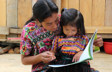 Mutter aus Guatemala liest ihrer Tochter vor