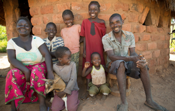 Familie Tembo aus Sambia zeigt eine ihrer Ziegen, die sie von ChildFund erhalten hat