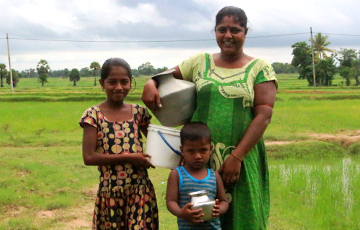 Mutter mit ihren zwei Kindern auf einer Wiese in Sri Lanka