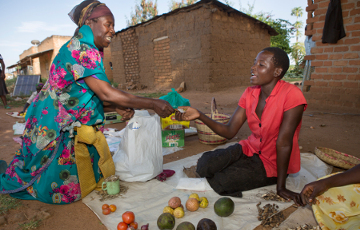 Frau kauft Nahrungsmittel bei einer lokalen Händlerin